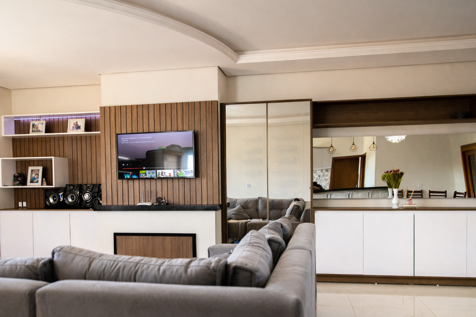 Imagem de sala com painel planejado.